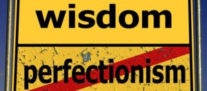 sign that says "wisdom and "perfectionism" crossed out